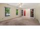Bright bedroom with carpet, ceiling fan, and two windows with decorative doors to the entry at 2417 Lawrence Dr, Raleigh, NC 27603