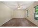 Spacious bedroom with neutral carpet, ceiling fan, and a large window for ample natural light at 2417 Lawrence Dr, Raleigh, NC 27603