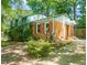 Charming brick home with mature trees, shrubs, and flowers and a rain barrel out front at 2417 Lawrence Dr, Raleigh, NC 27603