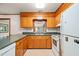 Kitchen with light wood cabinets, green countertops, white appliances, and linoleum flooring at 2417 Lawrence Dr, Raleigh, NC 27603