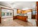 Open kitchen with wood cabinets, linoleum flooring, open to a second dining area with multiple windows at 2417 Lawrence Dr, Raleigh, NC 27603
