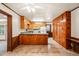 View of the kitchen with wooden cabinets and tiled floor, a ceiling fan and white appliances at 2417 Lawrence Dr, Raleigh, NC 27603