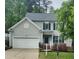 Charming home with an attached garage, neat landscaping, and a welcoming entrance with black front door at 2424 Horizon Hike Ct, Raleigh, NC 27603