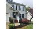Exterior view of home showcasing the entry way with brick steps, lush landscaping, and neutral colored siding at 2424 Horizon Hike Ct, Raleigh, NC 27603