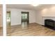 Living room featuring wood-look floors, a white fireplace mantel with black surround, and natural light at 2424 Horizon Hike Ct, Raleigh, NC 27603