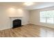 Bright living room boasting wood-look floors, a traditional fireplace, and minimalist design with a view of the window at 2424 Horizon Hike Ct, Raleigh, NC 27603