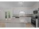 Open kitchen features white cabinets, stainless steel appliances and granite counters with view to backyard at 2941 Golden Oak Ct Ct, Raleigh, NC 27603