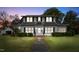 Charming two-story home with black shutters, landscaped yard, and inviting front entrance at dusk at 305 N Ellis Ave, Dunn, NC 28334