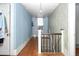 Hallway with wood floors, staircase, and vintage wallpaper at 305 N Ellis Ave, Dunn, NC 28334