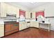 Retro kitchen with brick floor, vintage appliances, bright cabinets, and eat-in breakfast nook at 305 N Ellis Ave, Dunn, NC 28334