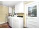 Functional laundry room featuring a washer, dryer, ample cabinet space, and durable tile flooring at 305 N Ellis Ave, Dunn, NC 28334