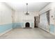 Spacious living room featuring a decorative fireplace, classic chandelier, and bright natural light at 305 N Ellis Ave, Dunn, NC 28334