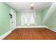 Open room with hardwood flooring and mint colored walls at 305 N Ellis Ave, Dunn, NC 28334