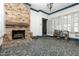 Bright sunroom features a brick fireplace, stone floors, and walls of windows for ample natural light at 305 N Ellis Ave, Dunn, NC 28334