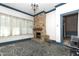 Spacious sunroom with brick fireplace, stone floor, and an abundance of windows providing natural light at 305 N Ellis Ave, Dunn, NC 28334