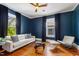 Living room has dark blue walls, hardwood floors and bright decor at 315 Oakwood Ave, Raleigh, NC 27601