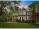 Charming home with manicured lawn, mature trees, and inviting front porch showcasing classic architectural details at 341 Heather Bluffs Dr, Garner, NC 27529