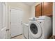 The laundry room includes a washer, dryer, and built in cabinets above at 341 Heather Bluffs Dr, Garner, NC 27529