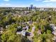Beautiful aerial view of neighborhood homes surrounded by lush trees, with city skyline in the distance at 3513 Bellevue Rd, Raleigh, NC 27609