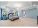 Spacious bedroom with blue walls, plush carpet and tray ceiling at 3513 Bellevue Rd, Raleigh, NC 27609