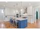 Modern kitchen with white cabinets, stainless appliances, and a blue center island at 3513 Bellevue Rd, Raleigh, NC 27609