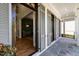 Inviting covered porch with gray stone flooring and view to bright green accent wall at 3513 Bellevue Rd, Raleigh, NC 27609