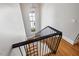 Bright stairway features hardwood treads, black metal railing, and a window for natural light at 3513 Bellevue Rd, Raleigh, NC 27609
