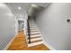 Beautiful staircase with hardwood steps, modern black railings, and neutral-colored walls at 3513 Bellevue Rd, Raleigh, NC 27609