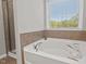 Bright bathroom features a large soaking tub by a window and a separate shower for a spa-like experience at 36 Argonaut Dr, Durham, NC 27705
