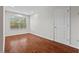 Bright bedroom with hardwood floors, window and closet door provides a simple and functional space at 36 Argonaut Dr, Durham, NC 27705