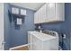 Well-lit laundry room featuring a washer, dryer, storage cabinets, and a decorative 'So Fresh' sign at 36 Argonaut Dr, Durham, NC 27705