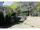 Green backyard featuring a well-maintained lawn, mature trees, and a black metal fence at 409 Courthouse Dr, Morrisville, NC 27560
