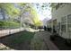 Spacious backyard with a metal fence, lush green trees, and a patio with seating at 409 Courthouse Dr, Morrisville, NC 27560