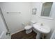 Clean half-bathroom featuring a pedestal sink and modern fixtures in a minimalist design at 409 Courthouse Dr, Morrisville, NC 27560
