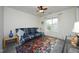 Cozy bedroom with a plaid futon, colorful rug, ceiling fan, and a window with light-filtering curtains at 409 Courthouse Dr, Morrisville, NC 27560
