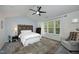 Spacious bedroom with a tray ceiling, decorative headboard, and comfortable seating area at 409 Courthouse Dr, Morrisville, NC 27560