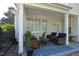 Covered patio with comfortable wicker furniture, patterned rug, and string lights at 409 Courthouse Dr, Morrisville, NC 27560