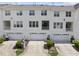 Rear view of townhomes featuring garages, balconies, and neat landscaping at 4210 Brynwood Ave, Durham, NC 27713