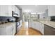 Spacious kitchen showcasing stainless steel appliances, granite counters, and hardwood floors at 4210 Brynwood Ave, Durham, NC 27713