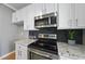 Close up of kitchen featuring stainless steel appliances, tile backsplash, and white cabinetry at 4210 Brynwood Ave, Durham, NC 27713