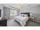 Main bedroom features tray ceilings, a ceiling fan, and large windows for natural light at 4210 Brynwood Ave, Durham, NC 27713