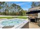 Backyard with a hot tub, seating area, and lush green grass, perfect for outdoor entertaining at 4304 S Greg Allen Way, Oxford, NC 27565