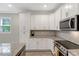 Well-lit kitchen with white cabinets, granite countertops, and stainless steel appliances at 4304 S Greg Allen Way, Oxford, NC 27565