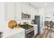 Close up of a spacious kitchen with stainless steel appliances, white cabinets, and quartz countertops at 5217 Invention Way, Raleigh, NC 27616