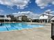 Community pool and clubhouse amenities with clear blue skies and fluffy white clouds overhead at 5217 Invention Way, Raleigh, NC 27616