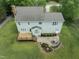 Aerial view of backyard featuring a deck, stone fire pit and large grassy yard at 5424 Westminster Ln, Fuquay Varina, NC 27526