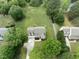 Aerial view of two-story home with green lawn surrounded by mature trees in a residential area at 5424 Westminster Ln, Fuquay Varina, NC 27526