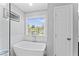 Modern bathroom featuring a standalone tub, window, and tiled walls at 5424 Westminster Ln, Fuquay Varina, NC 27526