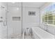 Elegant bathroom with a soaking tub, glass shower and large window at 5424 Westminster Ln, Fuquay Varina, NC 27526