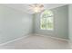 Carpeted bedroom with a ceiling fan, light green walls, and a large window at 5424 Westminster Ln, Fuquay Varina, NC 27526